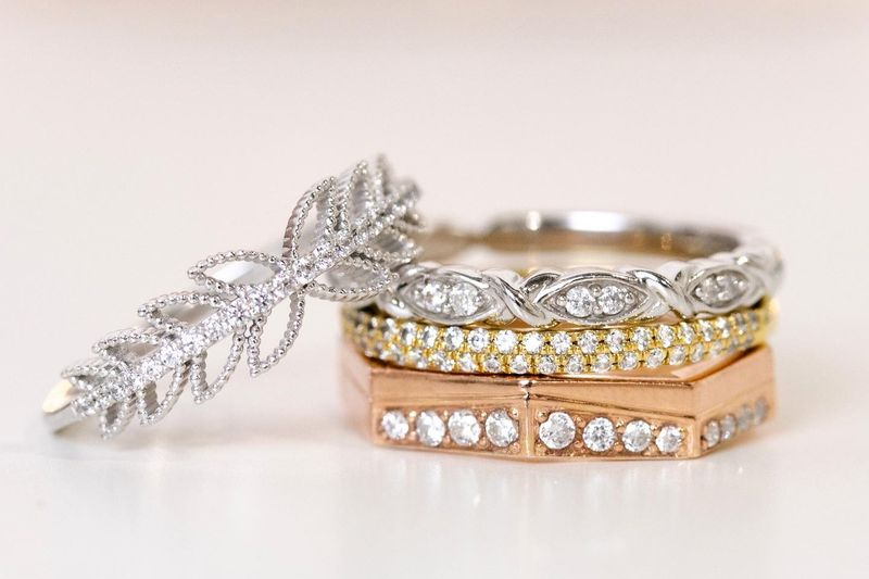 alliances ciselées et serties de diamants empilées